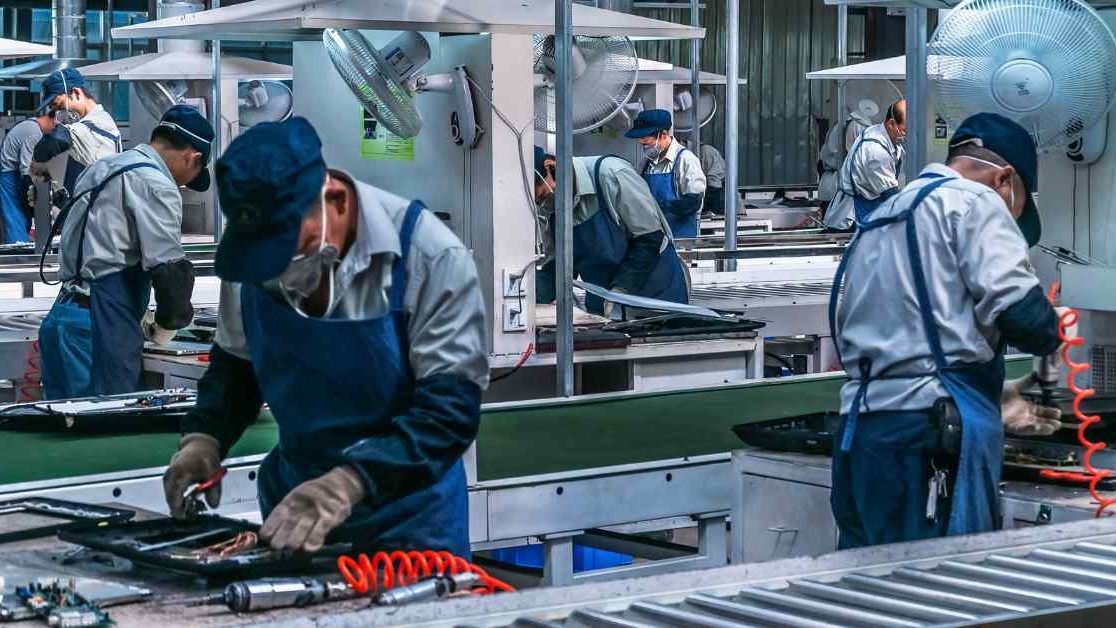 Linea di produzione di elettronica di consumo in una fabbrica cinese, operai al lavoro sui componenti